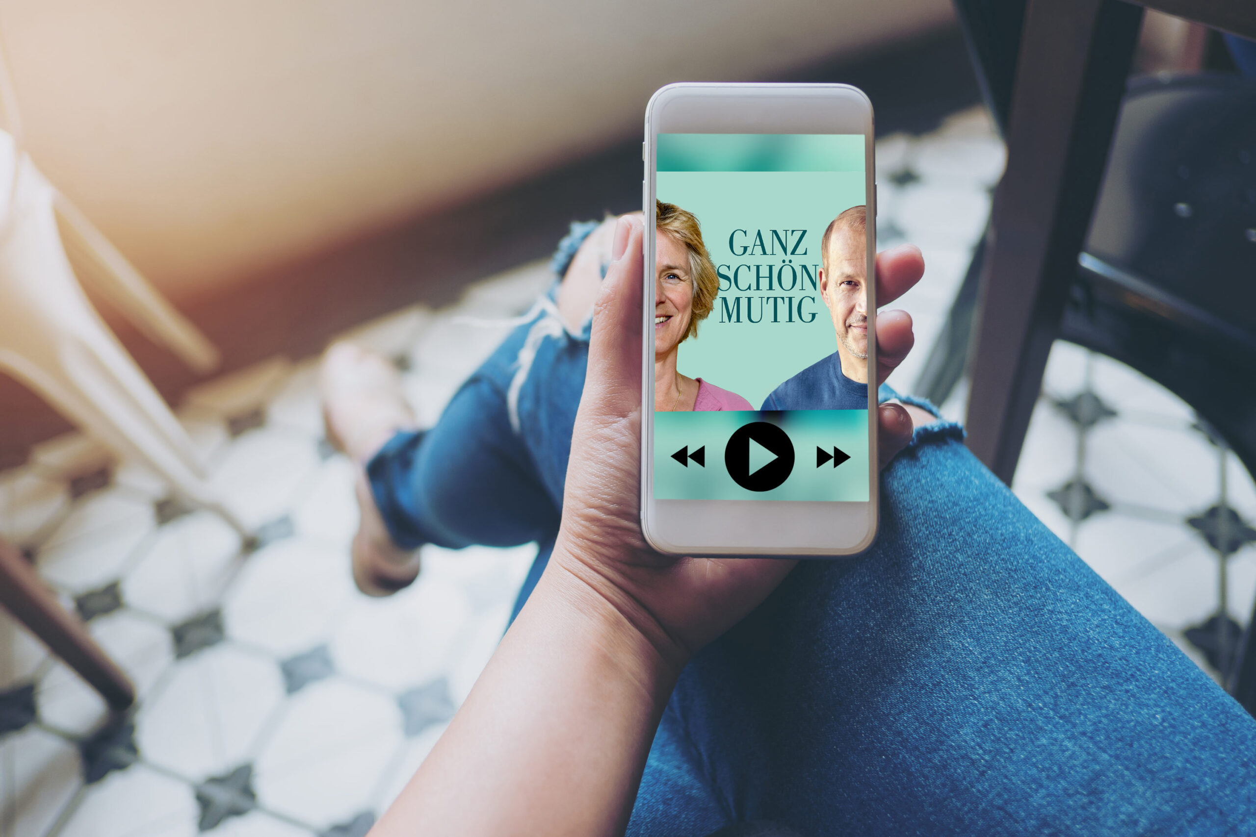 Eine Hand hält ein Smartphone, auf dem der Melanie Wolfers Podcast abgespielt wird